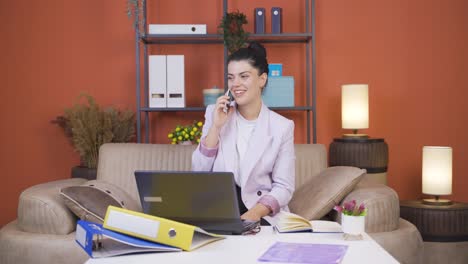 Mujer-Joven-Trabajadora-De-Oficina-En-Casa-Hablando-Por-Teléfono-Felizmente.